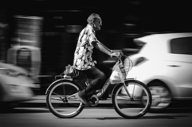 Older man riding in the city by pedaling