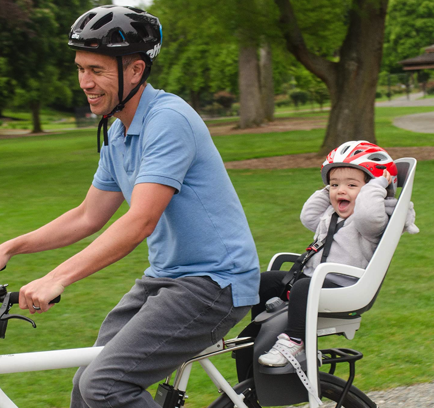 Man riding with baby in rear bike seat