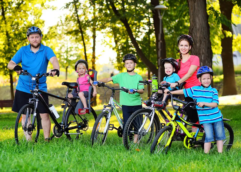 A family riding bikes together with small children in child seats that attach to bike