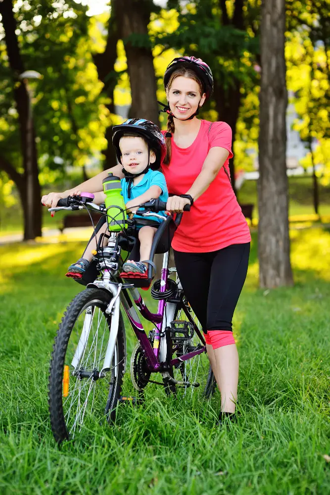 Toddler riding in front bike seat with mom.