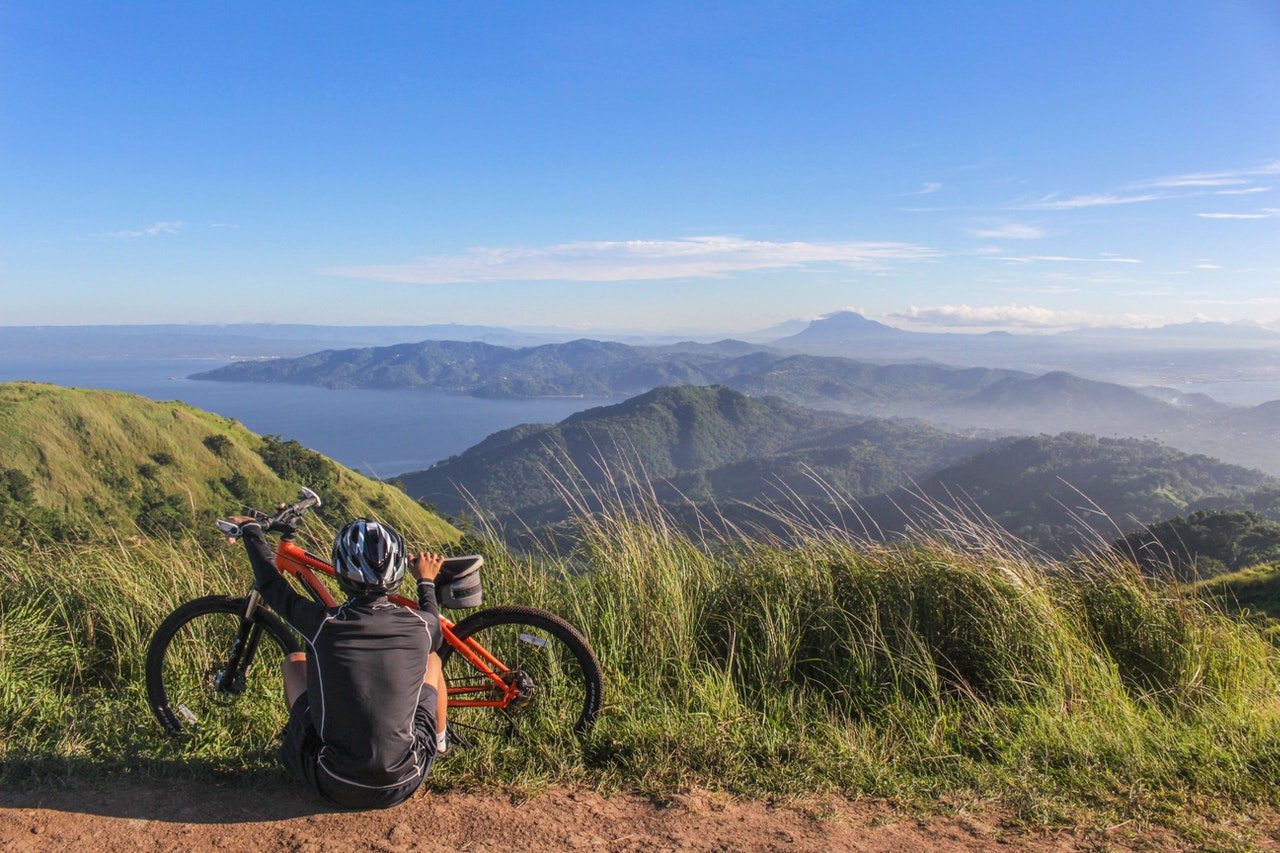 Man sitting in front of electric bike with view of mountains