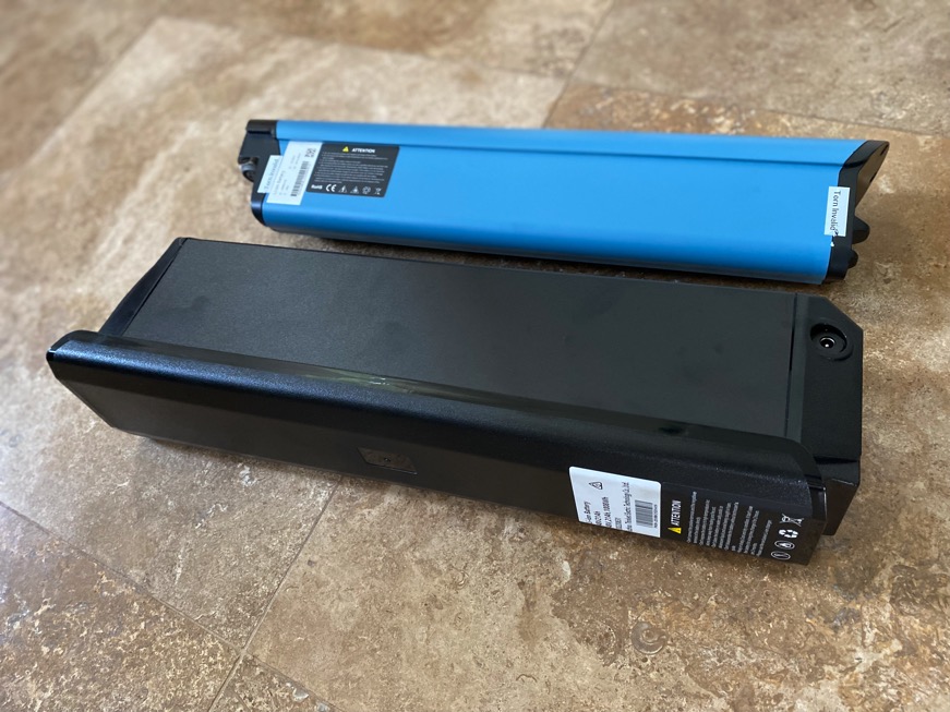 Two different e-bike batteries sitting side by side.