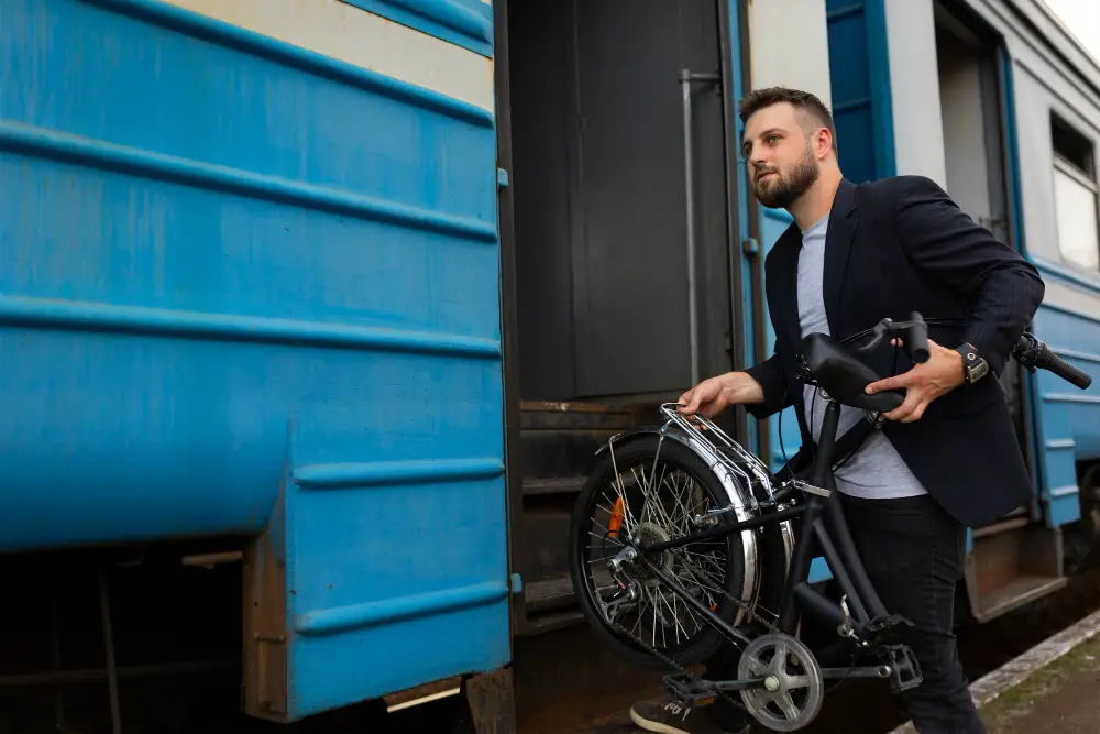 young-man-using-folding-bike-while-traveling-by-train