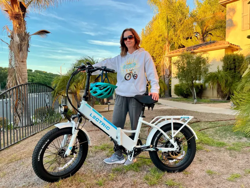 Woman standing next to white step-thru Lectric e-bike