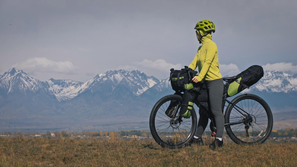 woman on e-bike in mountains touring with camping gear
