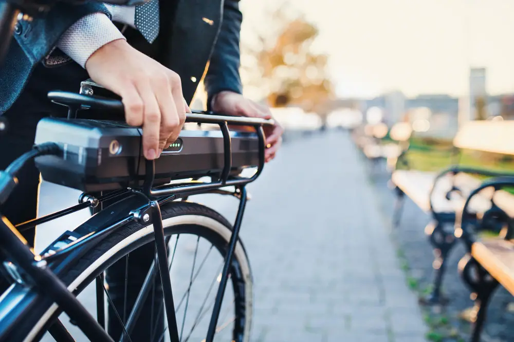 male hand adjusting ebike battery on electric bike