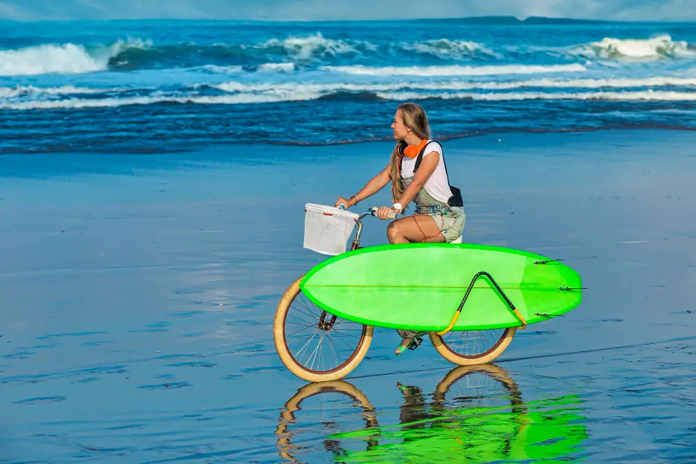 girl-with-surfboard-bicycle-beach