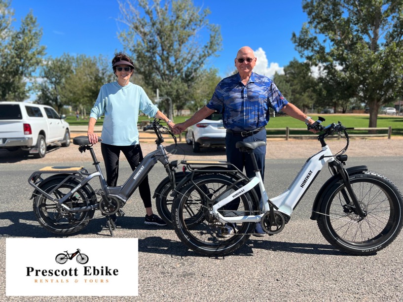 Elderly man and woman standing next to their Himiway e-bikes