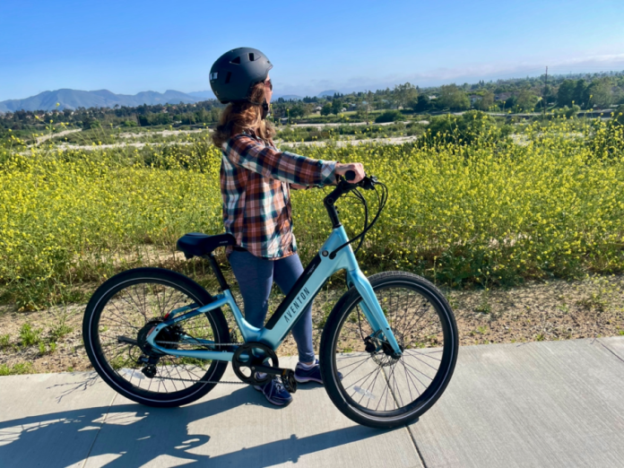 Woman standing next to blue electric bike