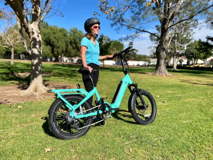 Woman standing next to Sea Turquoise E-Bike Color